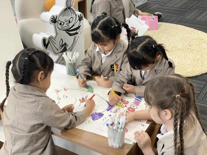 Trẻ nhỏ vẽ, tô màu Moomins. Ảnh: Khánh Linh