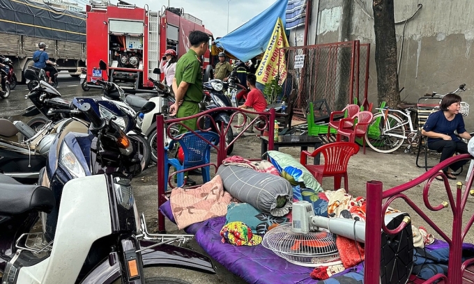 Người thuê trọ di dời đồ đạc, chăn, gối, tài sản ra ngoài trước khi ngọn lửa bao trùm dãy trọ. Ảnh: Đình Văn