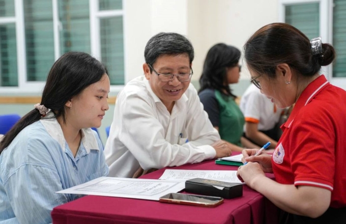Học sinh và phụ huynh làm thủ tục nhập học vào lớp 10 trường THPT Lê Quý Đôn, TP HCM, ngày 8/7. Ảnh: THPT Lê Quý Đôn