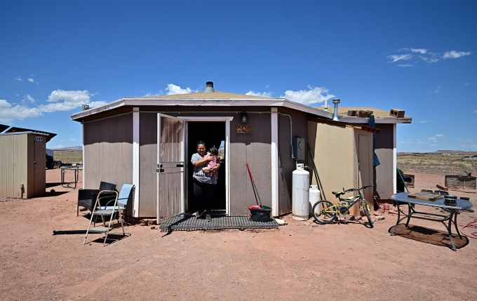 Gilberta Cortes, 42 tuổi, bế con bên ngoài nhà riêng tại Cameron, bang Arizona, hôm 9/7. Ảnh: AFP