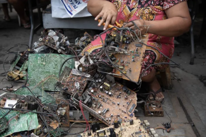 Rosalie Sedantes, vợ của Dexter Barsigan đang tháo dỡ linh kiện từ rác thải điện tử ở Manila. Ảnh: AFP/ TED ALJIBE