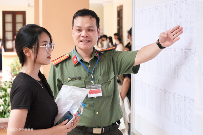 Cán bộ Học viện An ninh nhân dân hỗ trợ thí sinh tìm phòng thi. Ảnh: Dương Tâm