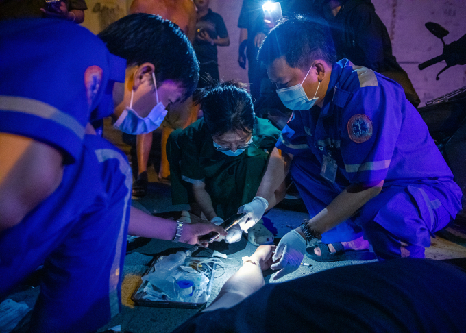 Anh Văn Thái Minh (43 tuổi, ngoài cùng bên phải) đang tìm ven đặt đường truyền tĩnh mạch cho một ca tai nạn giao thông. Ảnh: Phùng Tiên