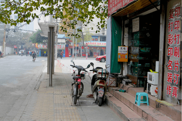 Xe máy điện đang sạc qua hộp sạc ở một cửa hàng tạp hóa tại Tứ Xuyên, Trung Quốc. Ảnh: frog