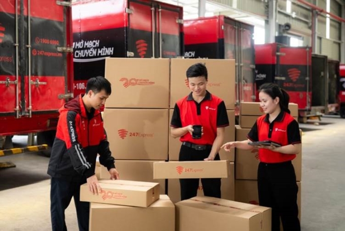 Nhân viên 247Express kiểm tra hàng hóa trước khi vận chuyển, trên thùng hàng in logo biểu tượng 20 năm của 247Express. Ảnh: 247Express