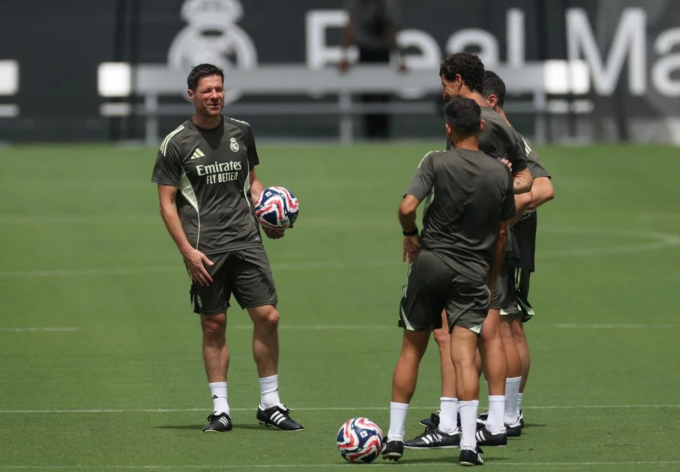 HLV Xabi trao đổi với các trợ lý. Ảnh: Reuters