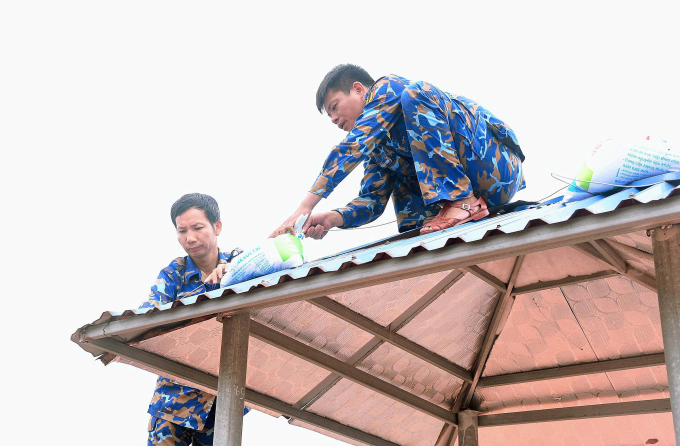 Bộ đội Hải Quân vùng 1 gia cố mái nhà. Ảnh: Hải Quân