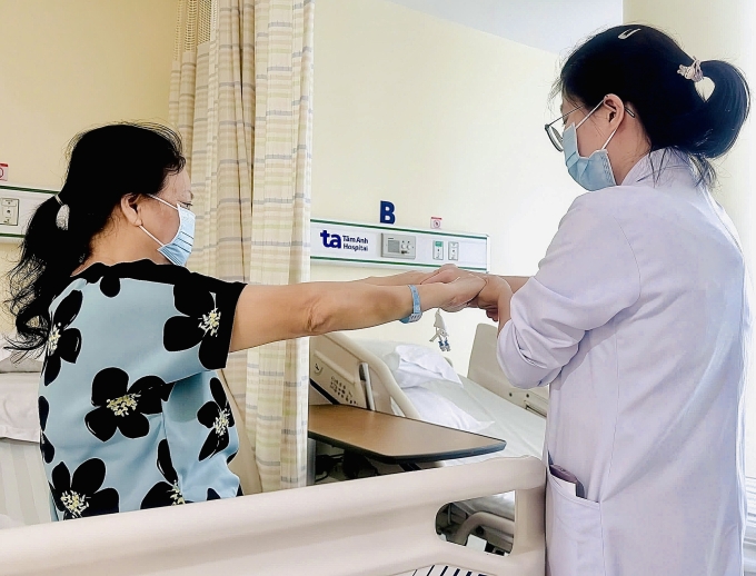 Bác sĩ kiểm tra cơ lực tay cho bà Lan trước khi xuất viện. Ảnh: Bệnh viện Đa khoa Tâm Anh
