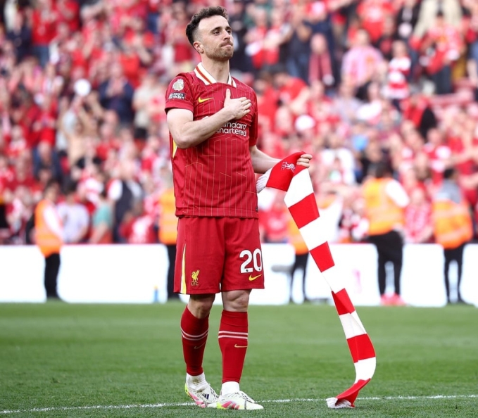 Jota đặt tay lên logo đội bóng trong tiệc mừng vô địch Ngoại hạng Anh trên sân Anfield ngày 26/5 trong lần cuối cùng xuất hiện trước người hâm mộ Liverpool. Ảnh: EPA