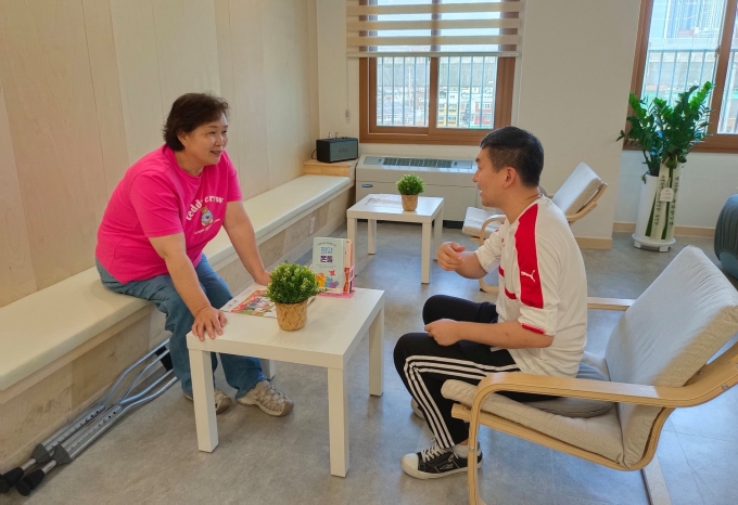 Bà Lee In-sook dựa vào kinh nghiệm của bản thân để tư vấn cho người khác đang gặp khó khăn về tâm lý tại trung tâm. Ảnh: Guardian
