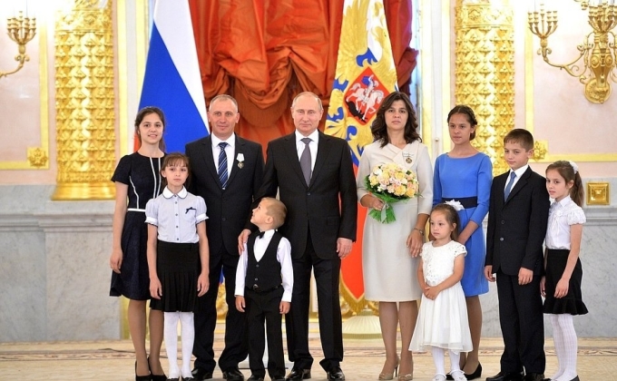 Tổng thống Nga Vladimir Putin trao huân chương vinh danh các cha mẹ đã giữ gìn nền tảng truyền thống gia đình bằng cách sinh 7 con trở lên trong buổi lễ tại Điện Kremlin ngày 1/6/2015. Ảnh: AFP