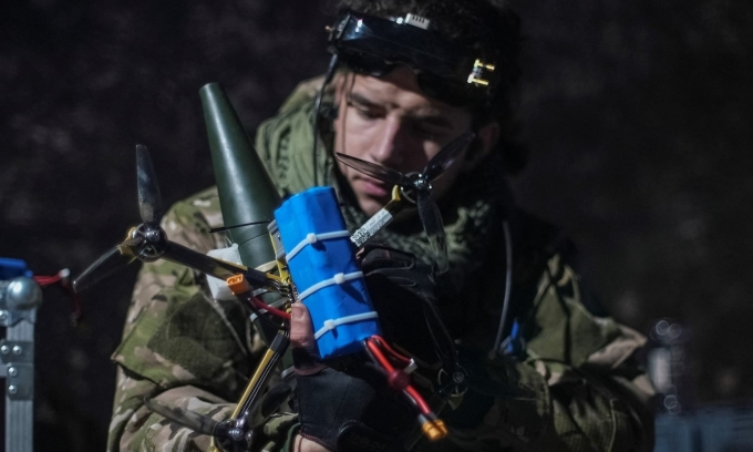 Một binh sĩ Ukraine gắn đạn pháo vào drone FPV gần thành phố Bakhmut, vùng Donetsk, hồi năm ngoái. Ảnh: Reuters