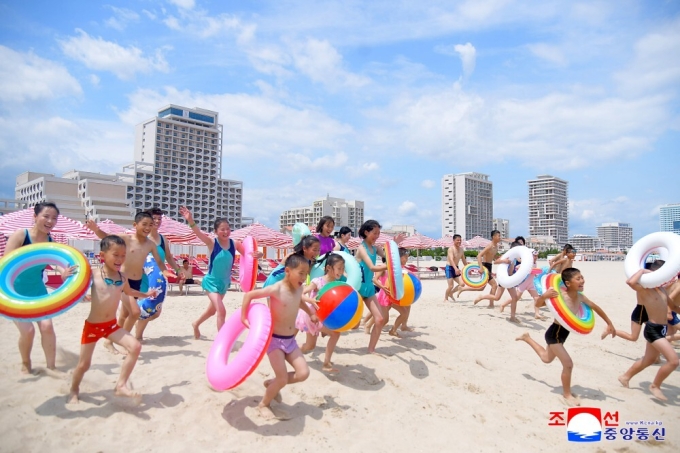 Người lớn và trẻ em vui đùa trên bãi cát thuộc khu nghỉ dưỡng Wonsan Kalma, Triều Tiên ngày 1/7. Ảnh: KCNA