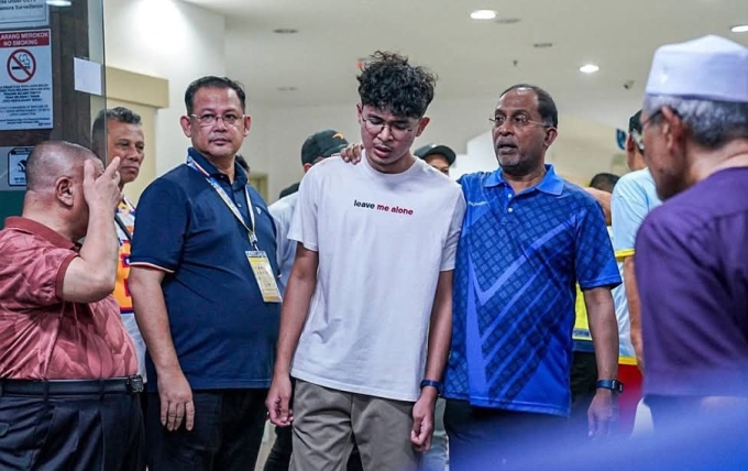 Fairiel Danish (áo trắng), con trai út của Firos Mohamed, bật khóc ở bệnh viện. Ảnh: Berita Harian