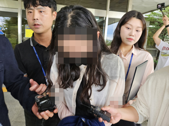 Nữ giáo viên bị áp giải rời Tòa án quận Daegu chi nhánh Andong ngày 14/7. Ảnh: Yonhap