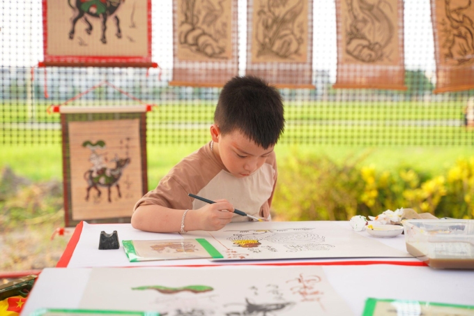 Trẻ em trải nghiệm tô vẽ tranh dân gian Đông Hồ - di sản văn hóa phi vật thể quốc gia. Ảnh: Centa Riverside
