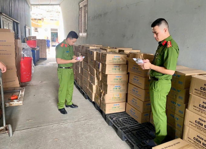 Cảnh sát kiểm tra nhà kho của một công ty trụ sở tại Hà Nội, thu hàng chục thùng carton đựng cồn giả. Ảnh: Hùng Lê