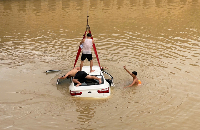 Lực lượng chức năng trục vớt ôtô 5 chỗ dưới sông Đào, chiều 13/7. Ảnh: Hùng Lê