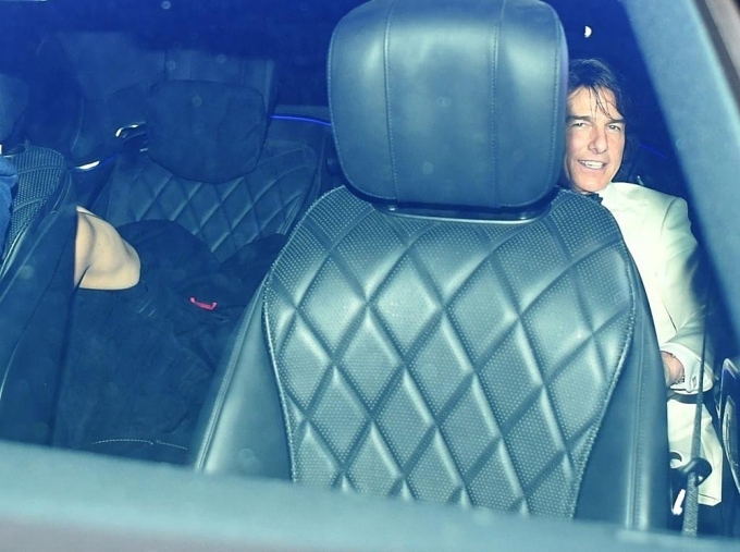 Tom Cruise ngồi trong xe hơi để rời khỏi nhà hàng. Bên cạnh anh là diễn viên Ana de Armas đang cố gắng giấu mặt. Ảnh: Backgrid