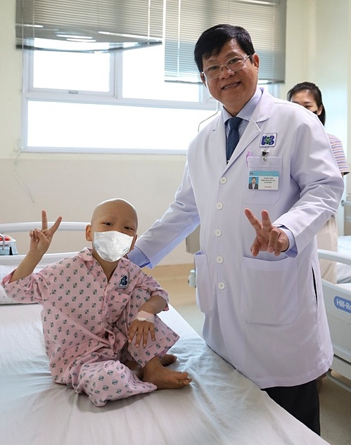 Bệnh nhi tạo dáng chụp hình cùng TS.BS Diệp Bảo Tuấn, Giám đốc Bệnh viện Ung bướu TP HCM trước khi xuất viện. Ảnh: Bệnh viện cung cấp