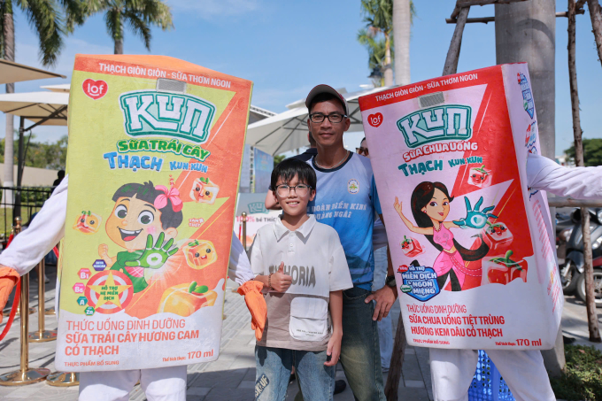Runner Nguyễn Minh và con trai chụp ảnh cùng mascot. Ảnh: VM
