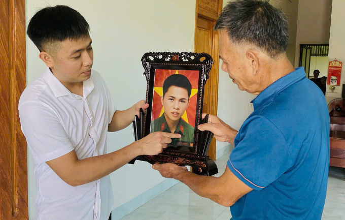 Anh Lê Thế Thắng trao ảnh phục dựng của liệt sĩ Lê Văn Ngãi (1949-1969) về cho người thân tại Thọ Xuân, Thanh Hóa, đầu tháng 7/2025. Ảnh: Nhân vật cung cấp