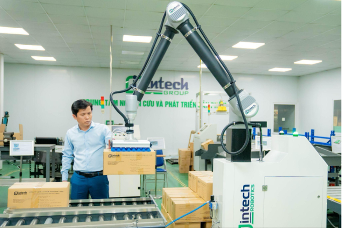 Ông Hoàng Hữu Thắng thử nghiệm vận hành mẫu robot do Intech Group phát triển. Ảnh: Intech