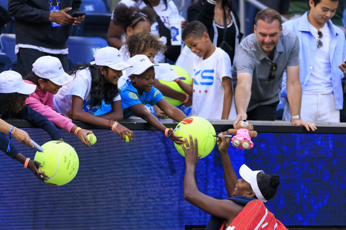 Venus Williams ký tặng khán giả sau trận thắng Ulrikke Eikeri/Eri Hozumi. Ảnh: Reuters
