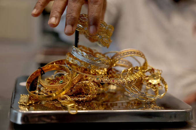 Một thợ kim hoàn cân vàng trang sức ở Ahmedabad, Ấn Độ, ngày 31/7. Ảnh: Reuters