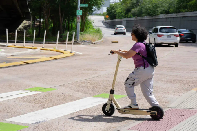 Claudia Vargas Corletto lái xe scooter điện đến chỗ làm ở Montrose, Houston. Ảnh: HC