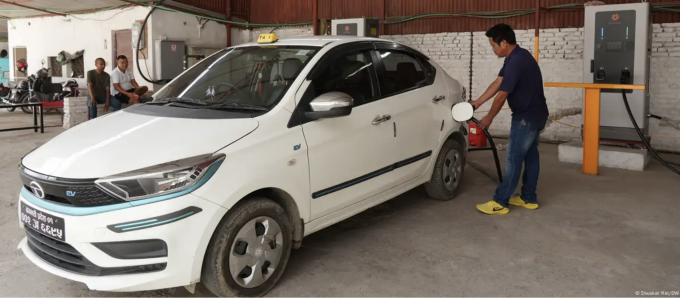 Một người dân ở thành phố Kathmandu đang sạc xe điện, tháng 7/2025. Ảnh: Diwakar Rai/DW