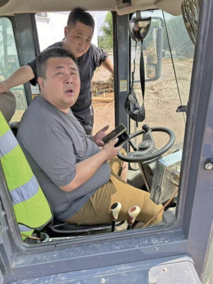 Wang Tianyu, 35 tuổi (áo xám) cùng bạn lái máy xúc cứu hơn 100 người trong trận mưa lũ lịch sử ở Bắc Kinh, cuối tháng 7/2025. Ảnh: Handout