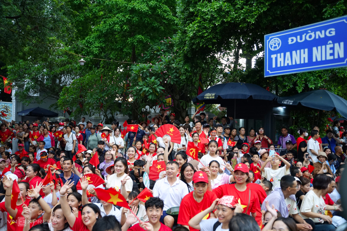 Người dân ngồi kín các vỉa hè nơi đoàn diễu binh, khí tài đi qua. Ảnh: Phạm Dự