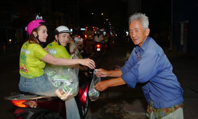 Vợ chồng Dương Ngọc Thái trao bánh mì cho người nghèo trong chuyến từ thiện đầu năm.