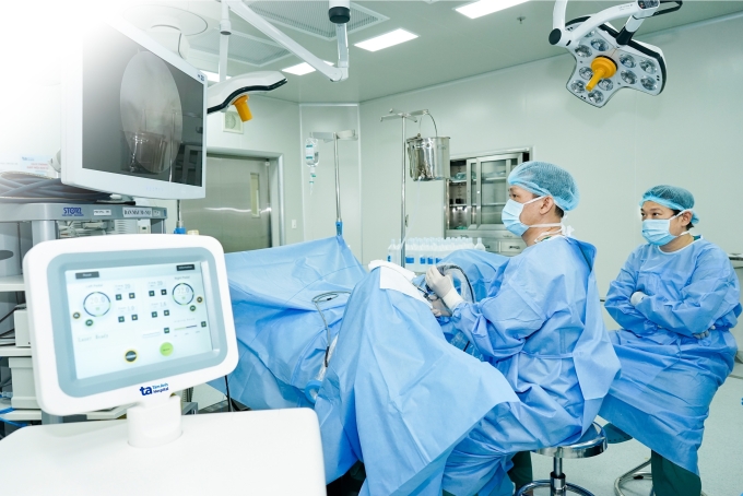 Bác sĩ Cương (trái) cùng BS.CKI Phạm Thế Anh phẫu thuật bóc nhân tuyến tiền liệt bằng laser cho ông Carter. Ảnh: Bệnh viện Đa khoa Tâm Anh