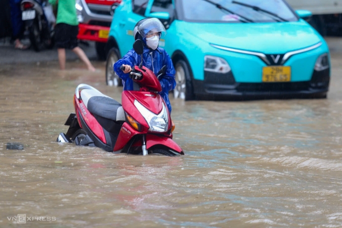 Giao thông tại quốc lộ 6 tê liệt, vị trí ngập sâu nhất đến gần một mét, nhiều ôtô, xe máy chết máy đứng giữa dòng. Một số người gửi xe để lên đường sắt Hà Đông - Cát Linh đi làm. Ảnh: Gia Chính