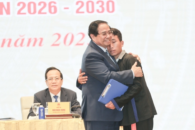 Thủ tướng Phạm Minh Chính ôm trưởng bản Mùa A Thi - người đã giúp 90 người thoát thảm họa lũ quét. Ảnh: TTXVN