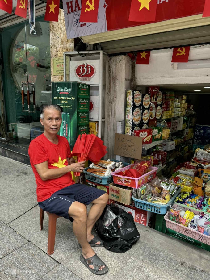 Ông Hải chuẩn bị 1.000 cờ và quạt miễn phí đặt trước cửa nhà dành tặng người dân xem diễu binh trên phố Quán Thánh, trưa 29/8. Ảnh: Quỳnh Nguyễn