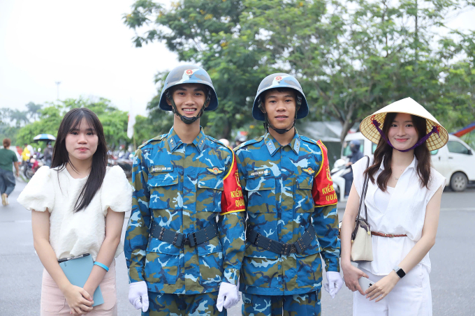Nguyễn Thùy Linh, 22 tuổi (ngoài cùng bên phải) cùng em gái Ngọc Bích chụp ảnh cùng các chiến sĩ tại Làng Văn hóa các dân tộc Việt Nam, sáng 2/7. Ảnh:Quỳnh Nguyễn