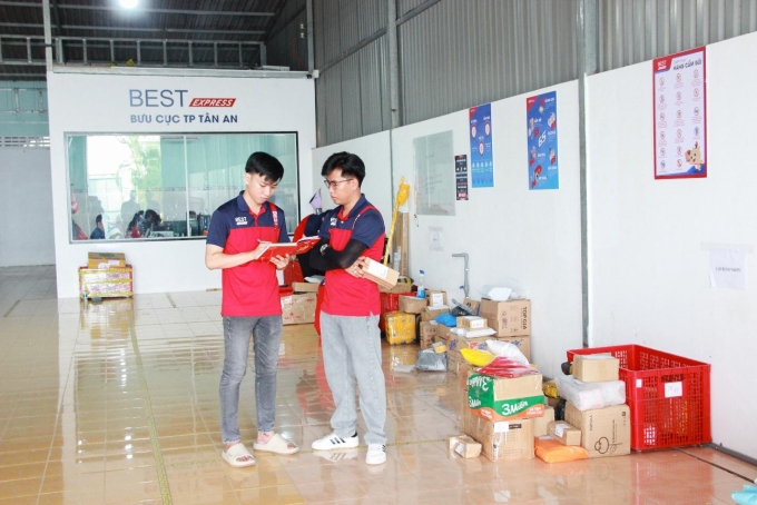 Anh Nhân (phải), quản lý bưu cục, trao đổi công việc cùng đội ngũ.  Ảnh: BEST Express