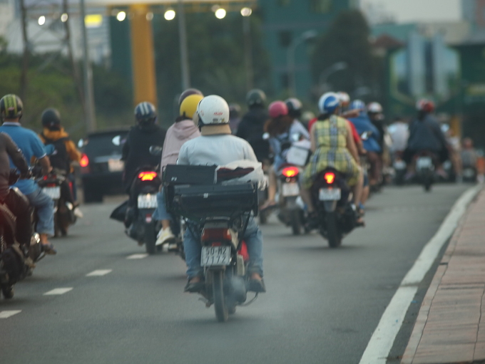 Khói đen từ một xe máy chạy trên cầu Bình Triệu vào trung tâm TP HCM. Ảnh: Giang Anh