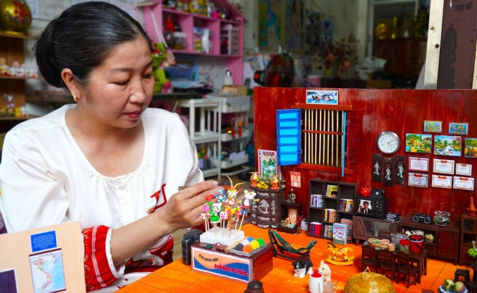 Chị Phúc đang làm một ngôi nhà mô hình. Ảnh: An Minh