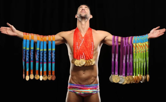 Michael Phelps tạo dáng với tất cả huy chương Olympic. Ảnh: Sports Illustrated