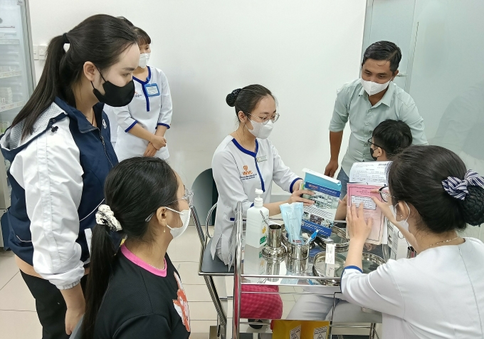 Vợ chồng chị Điệp đưa hai con đi tiêm vaccine sốt xuất huyết tại VNVC Sunrise City. Ảnh: Khánh Hòa