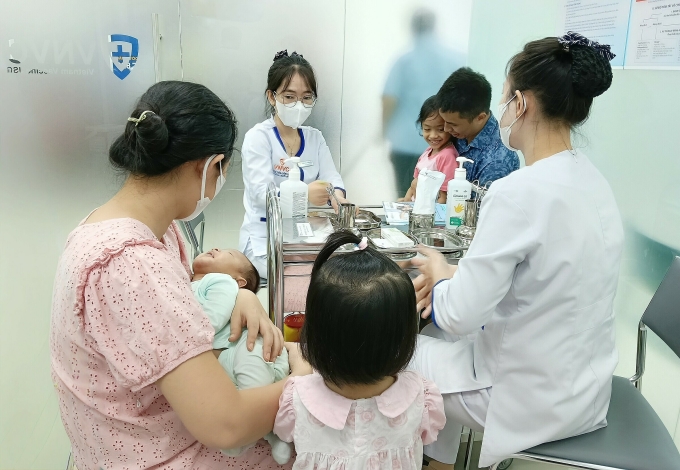 Vợ chồng chị Phượng đưa ba con đi tiêm vaccine trong ngày đầu nghỉ lễ. Ảnh: Khánh Hòa