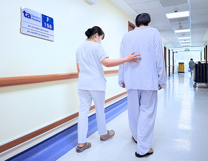 Kỹ thuật viên hướng dẫn anh Thanh tập phục hồi chức năng trước khi xuất viện. Ảnh: Bệnh viện Đa khoa Tâm Anh