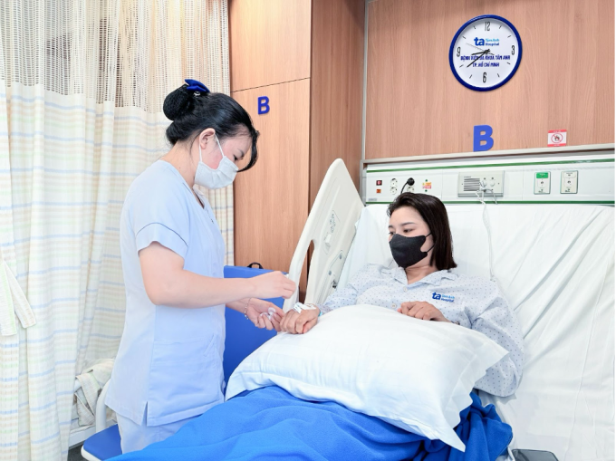 Điều dưỡng chăm sóc, kiểm tra vị trí truyền tĩnh mạch cho chị Anh sau phẫu thuật. Ảnh: Bệnh viện Đa khoa Tâm Anh