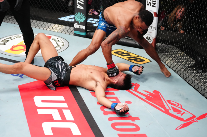 Elijah Smith ra đòn khi Toshiomi Kazama nằm sàn bất tỉnh ở trận đấu hạng gà UFC Vegas 109 tại Las Vegas, Mỹ ngày 9/8. Ảnh: UFC