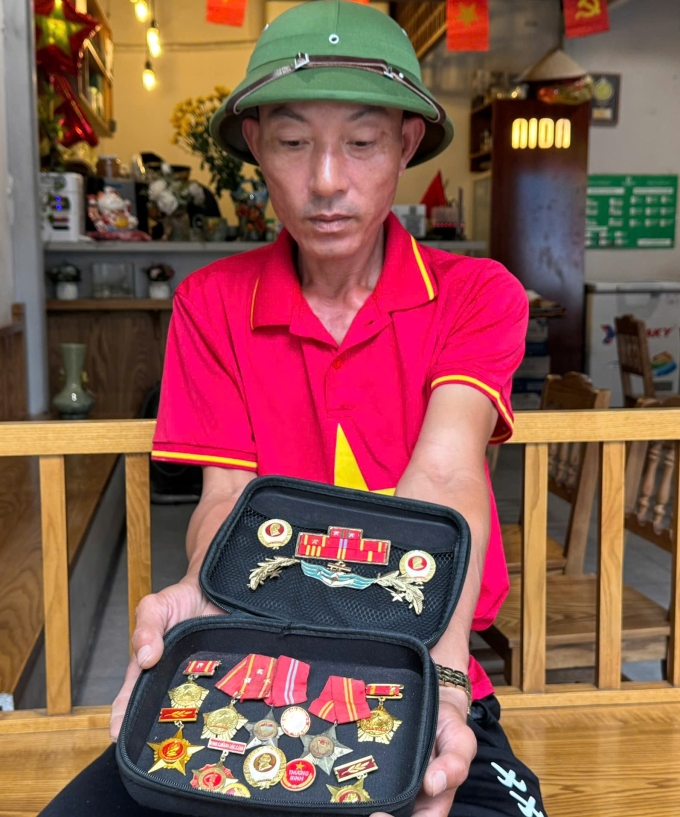 Anh Mai mang theo hộp đựng kỷ niệm chương của bố đến Hà Nội, hôm 25/8. Ảnh: Phạm Nga