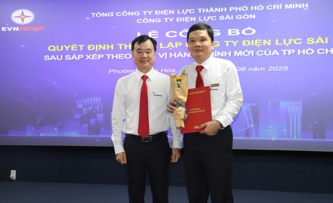 Ông Trần Vũ Quang (trái) trao quyết định thành lập đến ông Hoàng Đình Ấn - Giám đốc Công ty Điện lực Sài Gòn. Ảnh: EVNHCMC